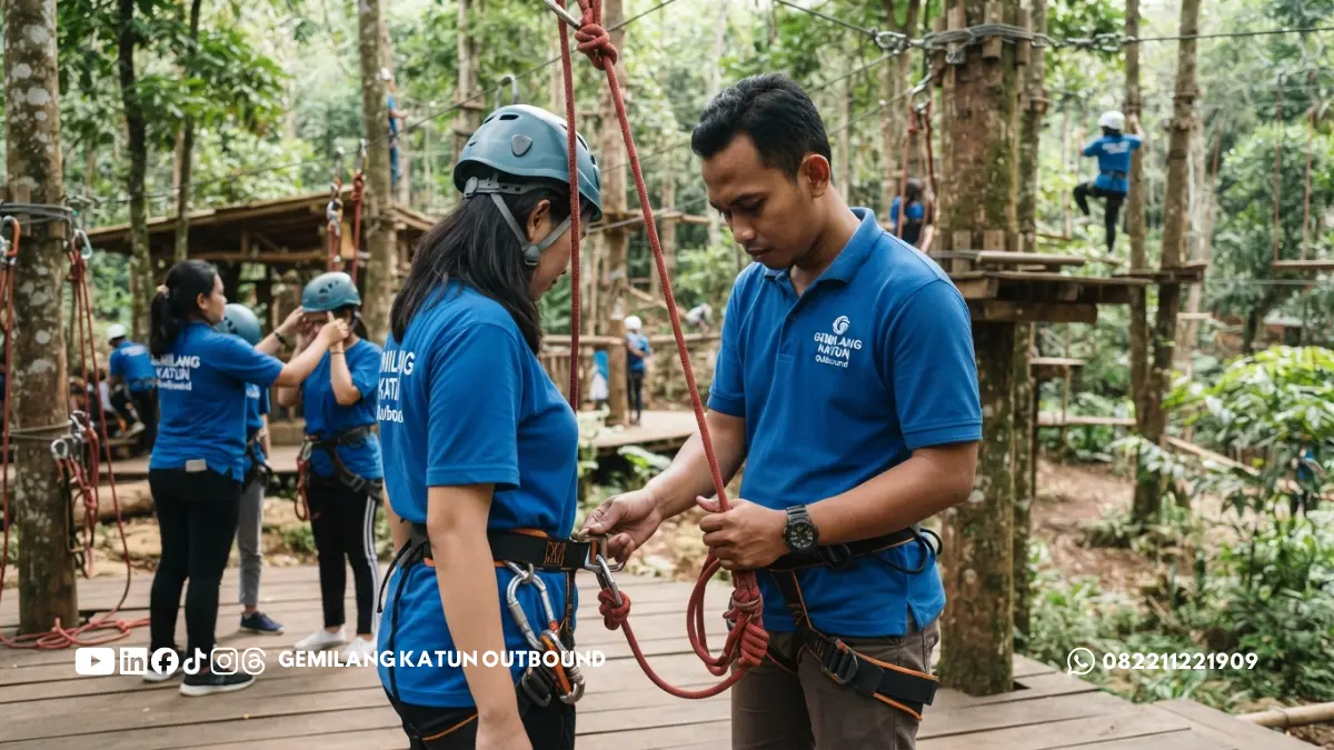 Instruktur memeriksa harness dan tali pada area outbound